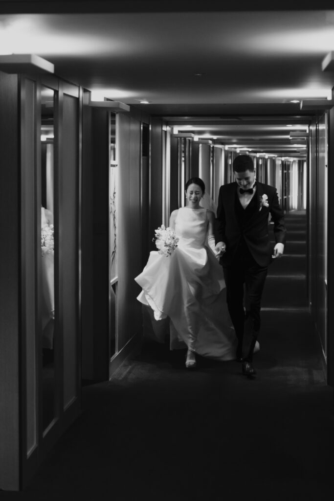 A bride and groom running through the Seoul Grand Hyatt Hotel's hallway.
