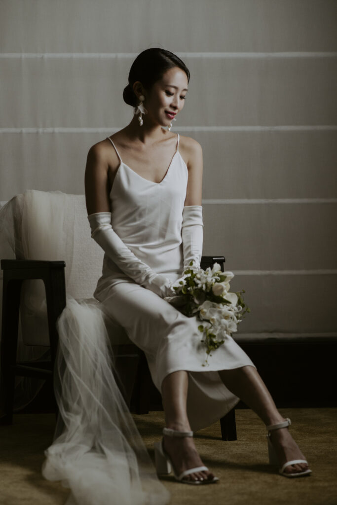 A bride in a white dress sitting on a chair at Seoul Grand Hyatt Hotel.
