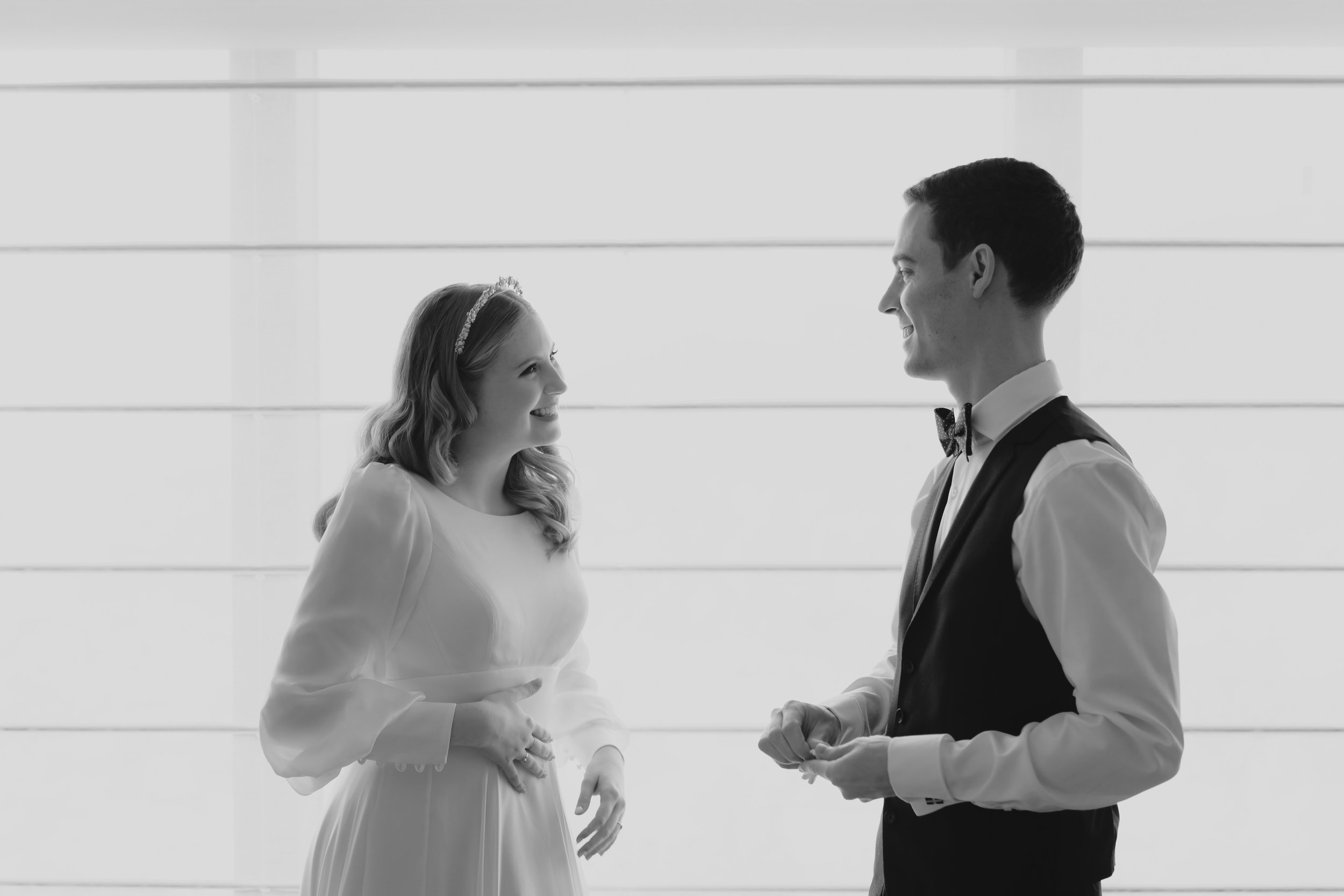 A bride and groom talking in front of a window at the Seoul Grand Hyatt Hotel