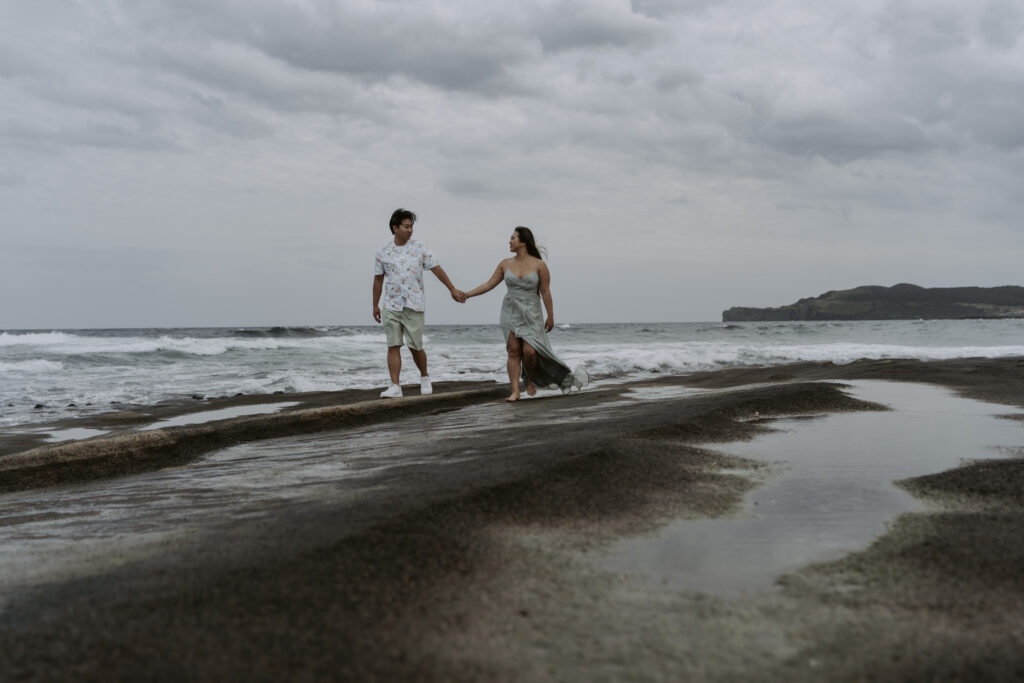 a couple walking on the beach in jeju island during their prewedding photoshoot in september