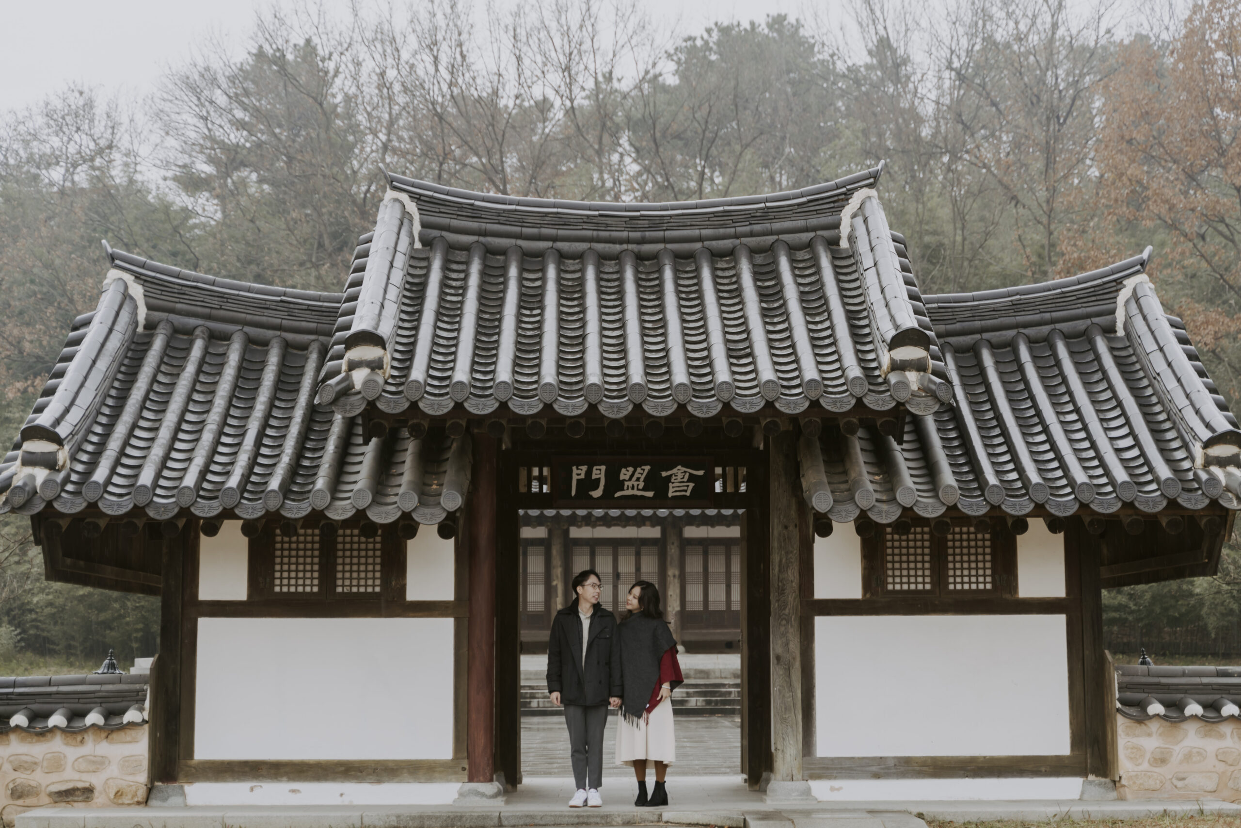 a couple at their autumn pre-wedding shoot in south korea at a hanok house
