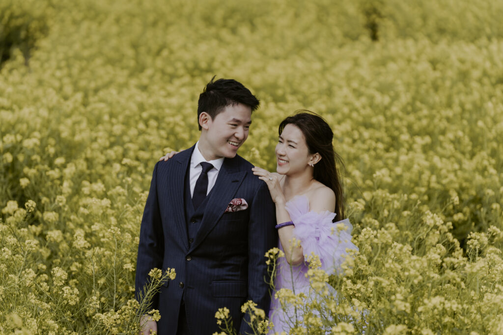 A couple from Singapore posing in a canola field in the warm weather of spring.
