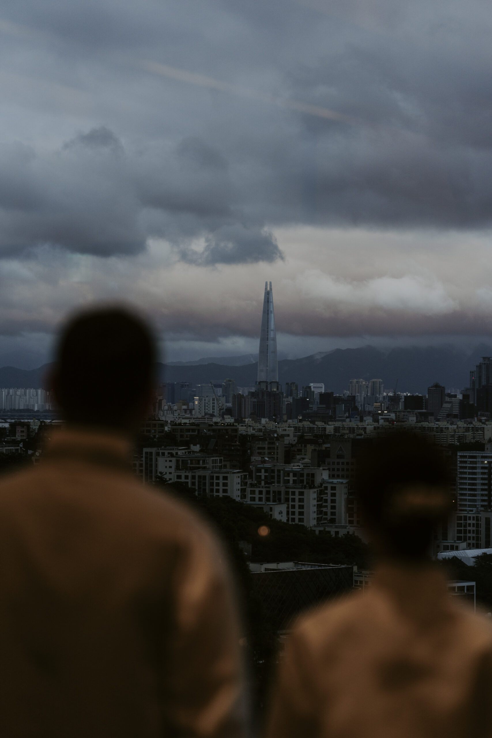 A couple looking at the Seoul skyline from the Grand Hyatt Hotel.