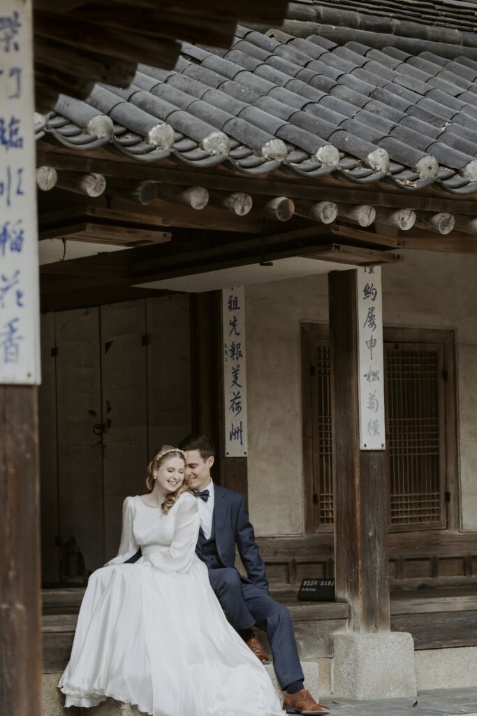 A newlywed couple embracing on the steps of an Asian building during a Seoul elopement.