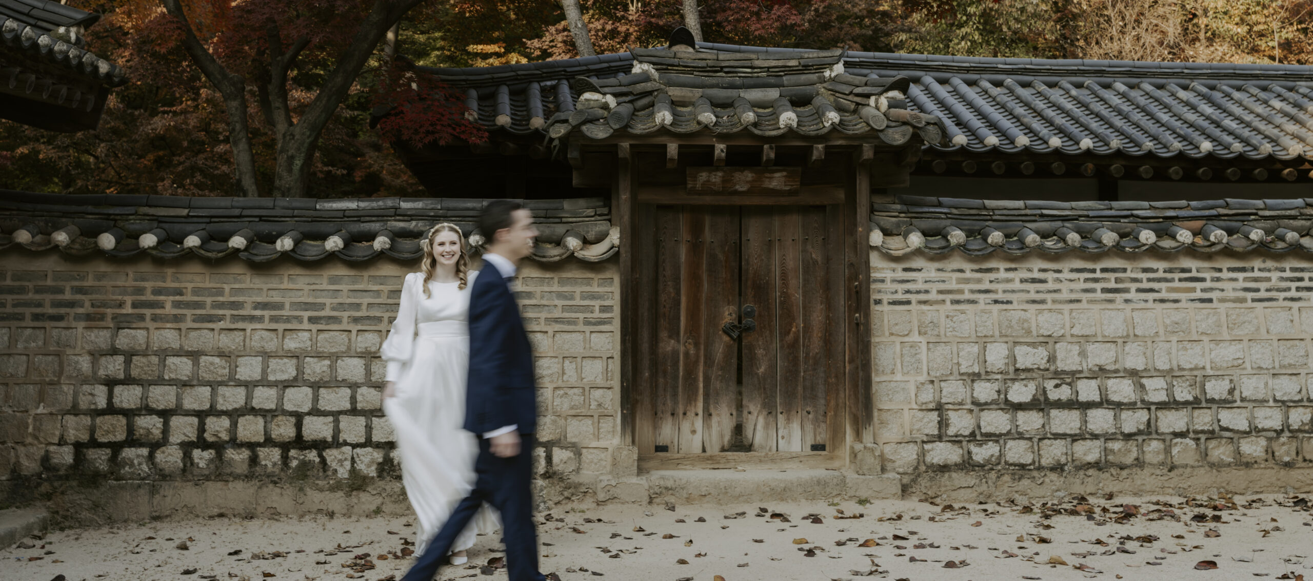 A bride and groom enjoying a Seoul elopement in front of a Korean house.