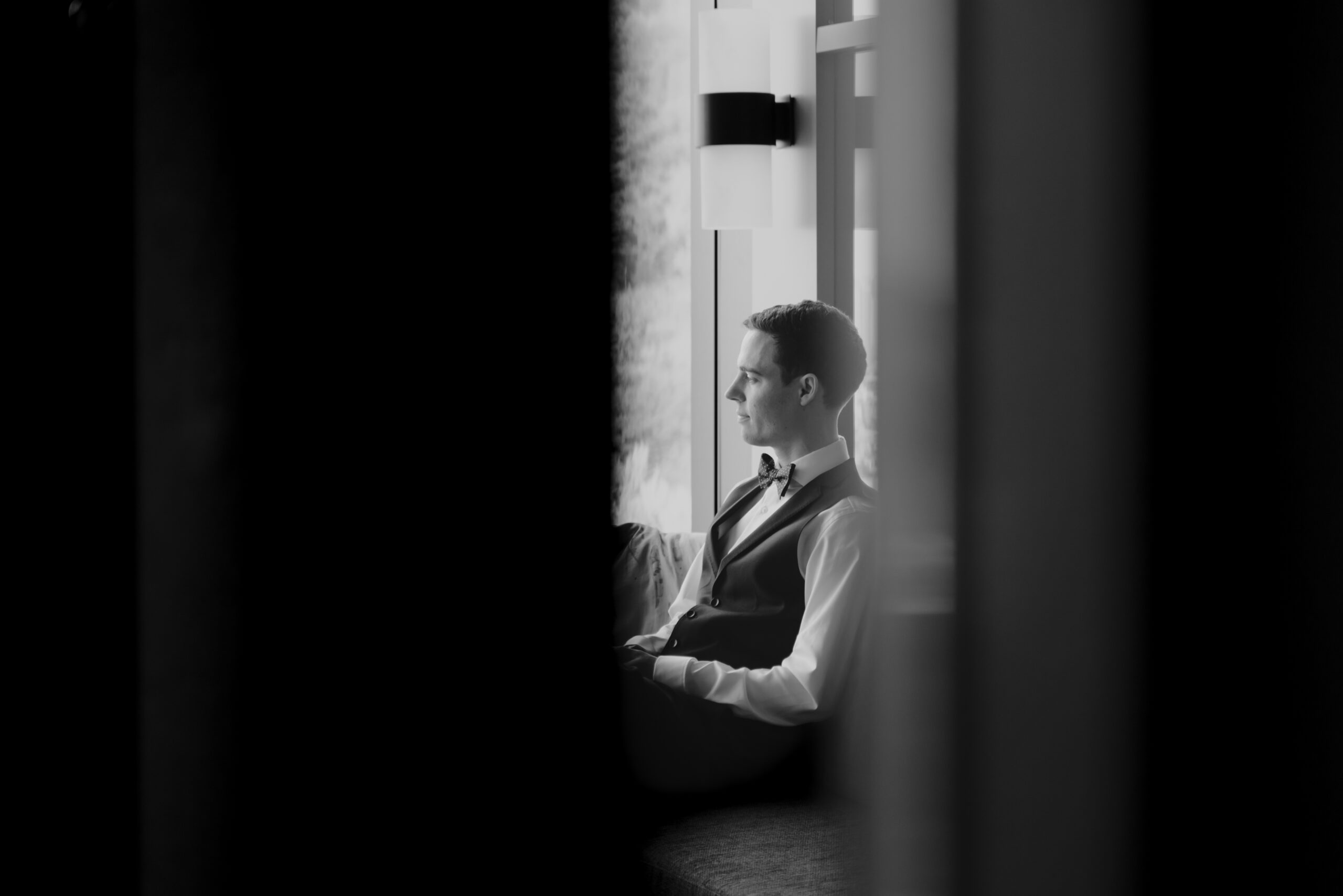 A man sitting in front of a window during a seoul elopement.