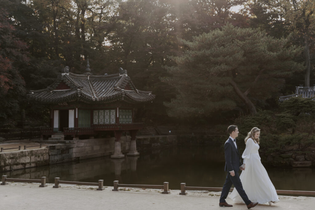 A couple walking in front of a pagoda in Korea.