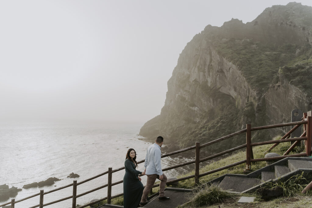 the couple walking up the mountain stairs of jeju island for their pre-wedding