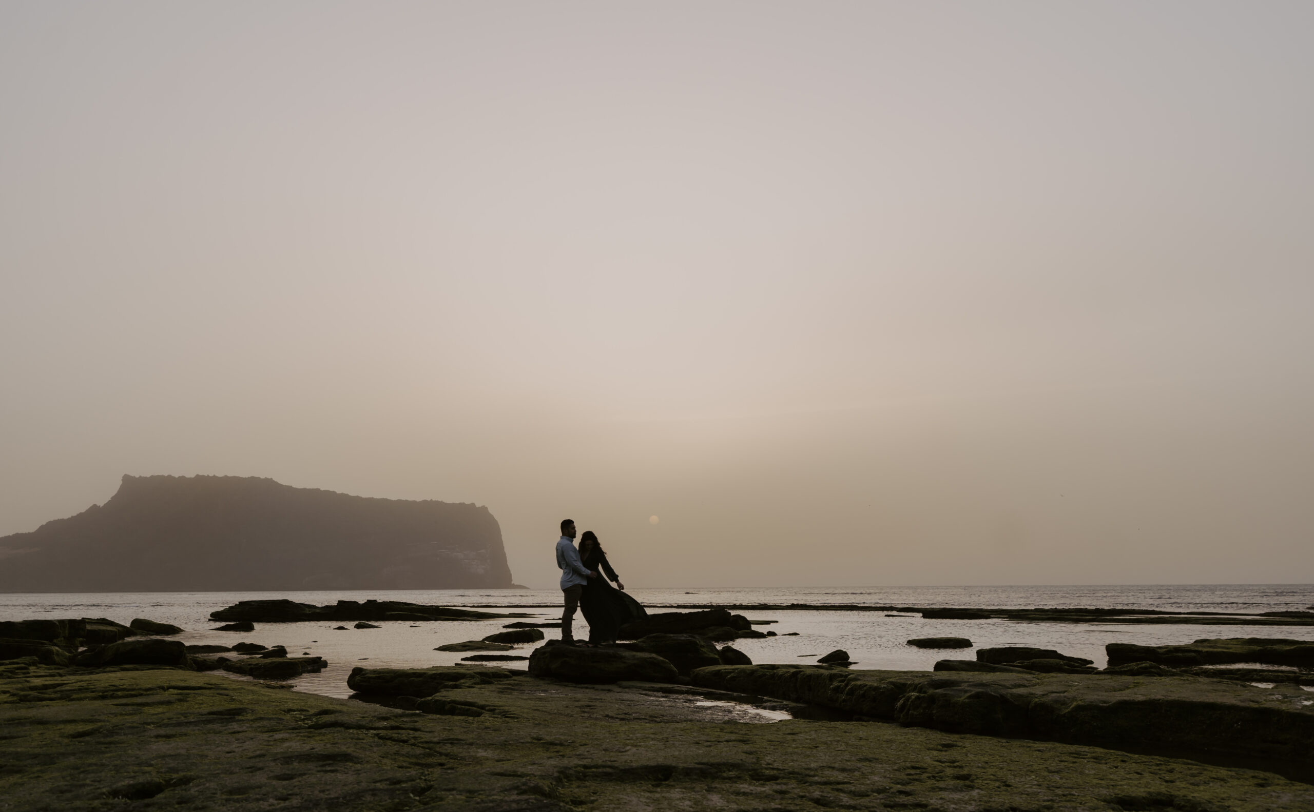 a couple watching a sunrise in jeju island