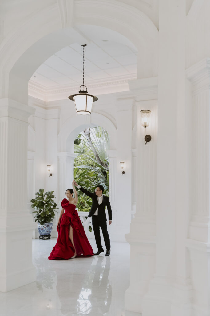A wedding couple posing in the iconic hallway of Raffles Hotel Singapore.
