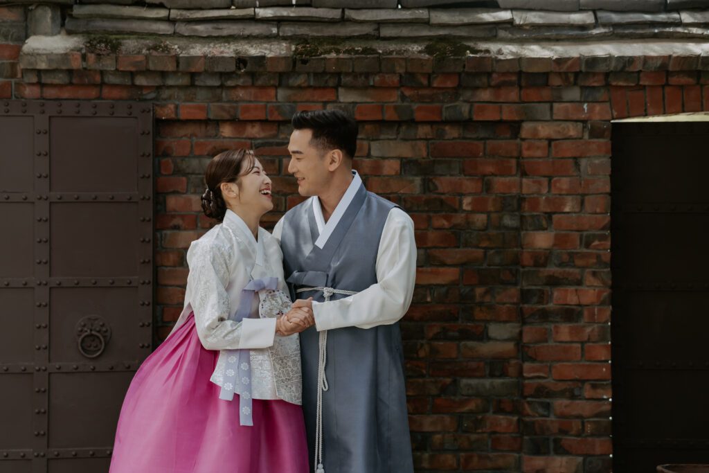 A couple in traditional korean hanbok standing in a hanok wedding venue in Seoul.