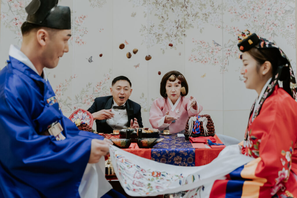 The bride's parents throw chestnuts and jujubes at the pyebaek ceremony.
