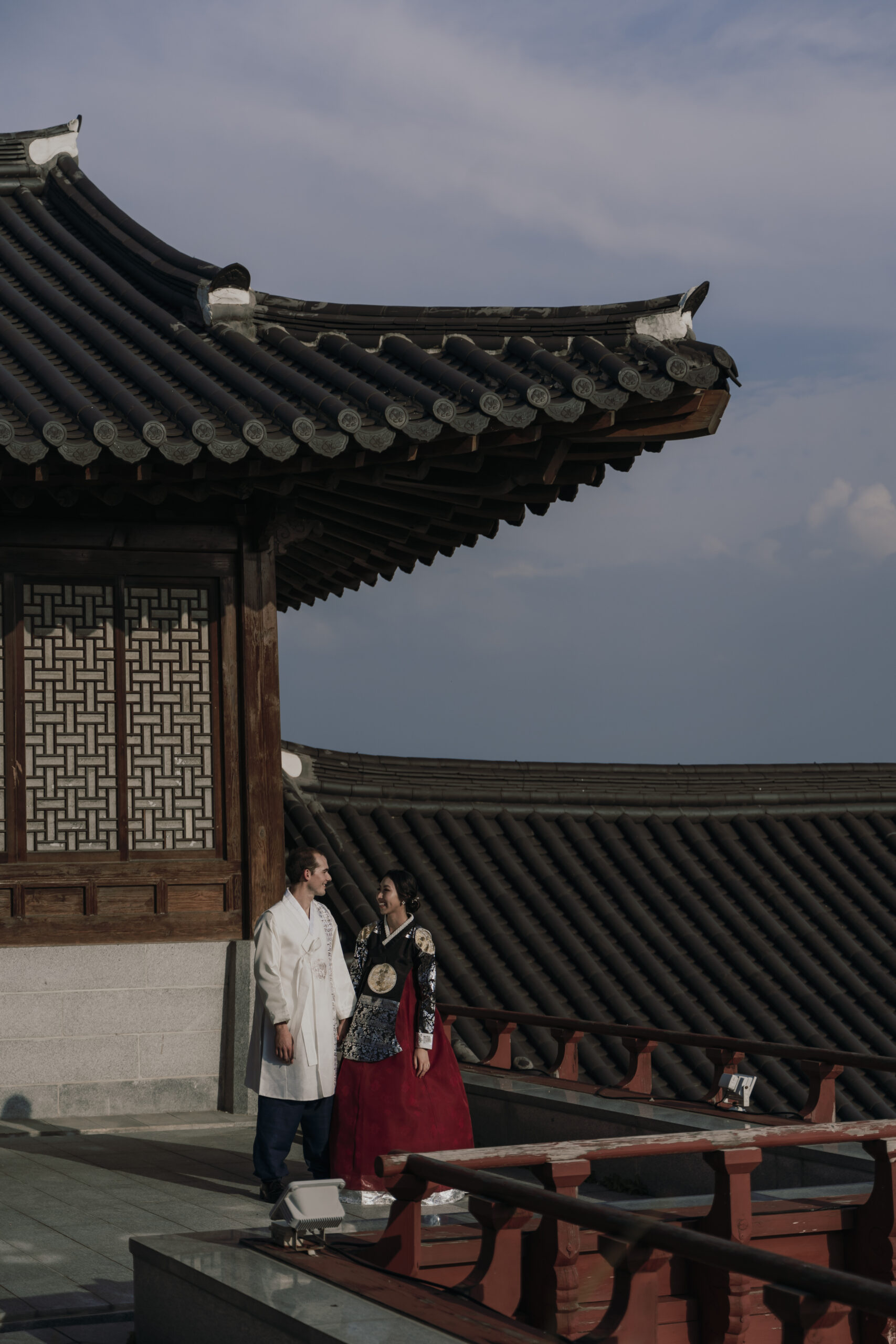 A couple standing on the roof of a korean building, a place they found when planning a wedding in Korea.