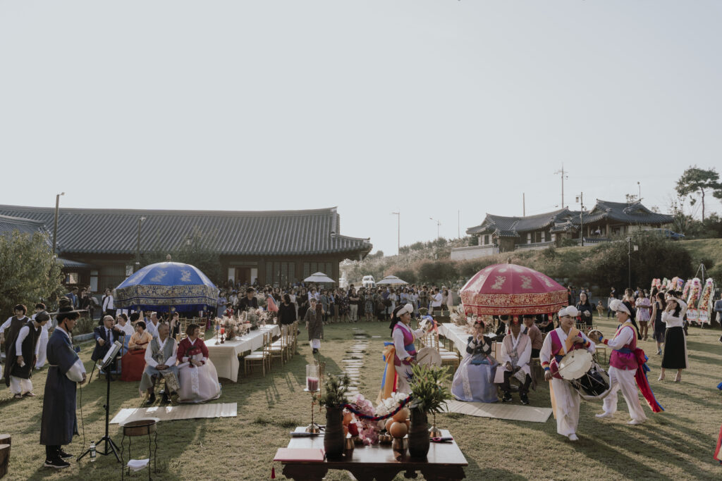 A traditional korean wedding with many people and umbrellas in south korea