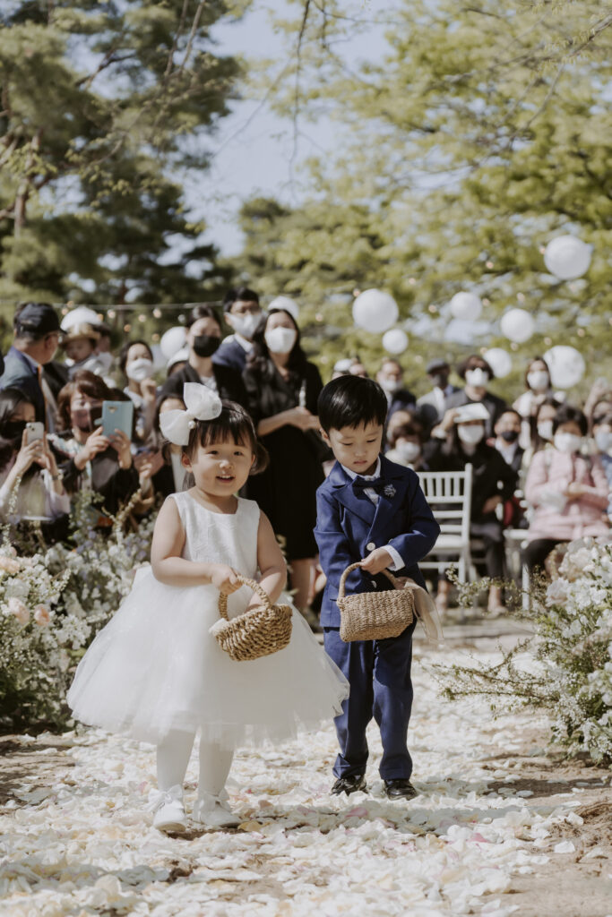 Two children walking down the aisle at a korean wedding ceremony.