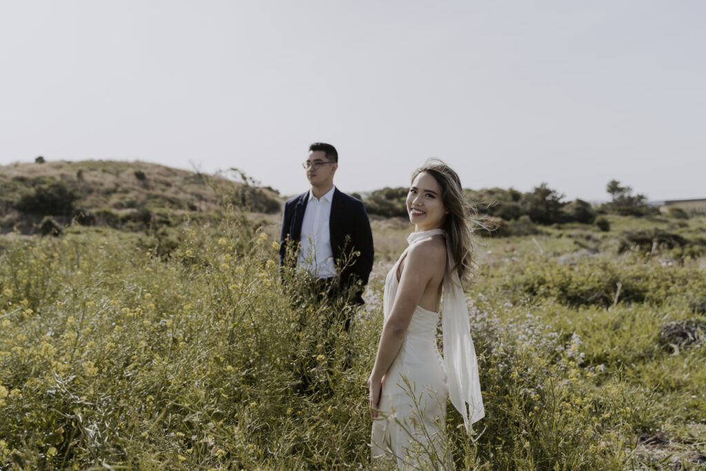 a bride and groom pose in jeju's famous canola fields during their prewedding photoshoot