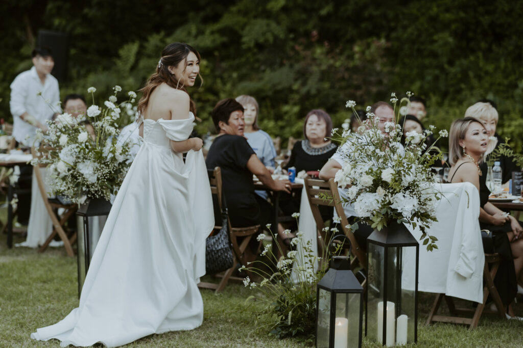 A bride in a white dress standing at an outdoor wedding in south korea.