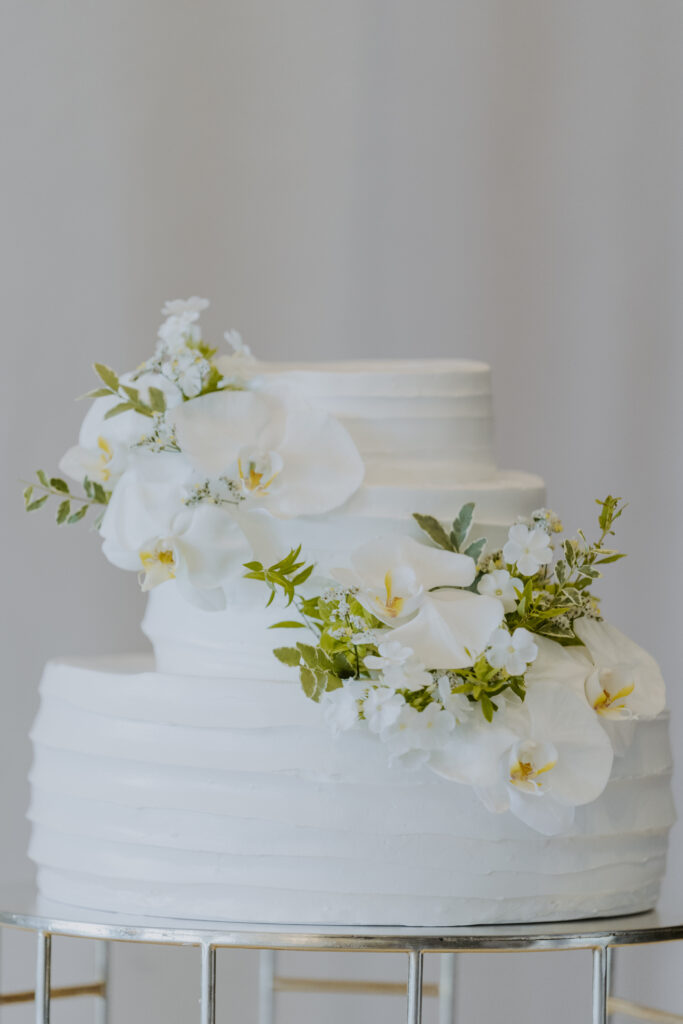 A white wedding cake with white flowers on it.