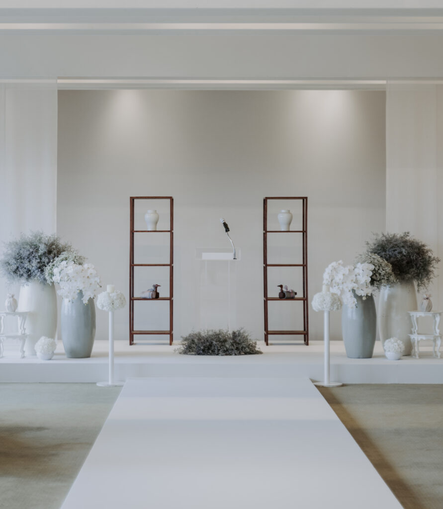 A white room with vases on the floor.