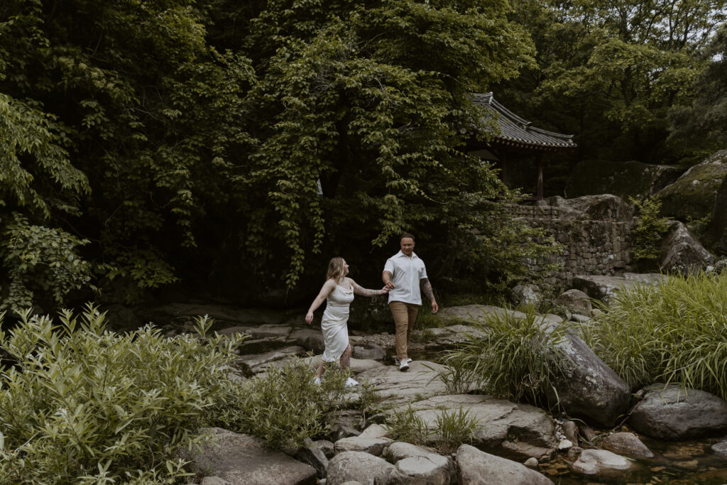 A damyang pre-wedding couple exploring a woodland stream.