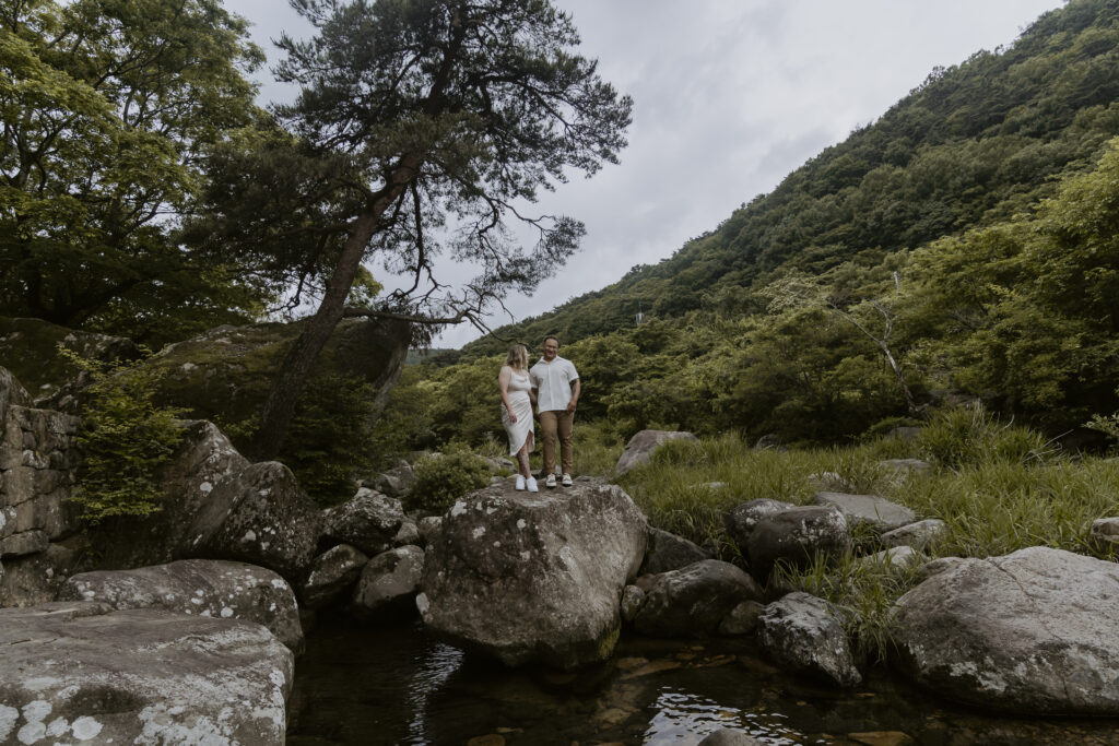 A couple standing on rocks in outside in Damyang, South Korea