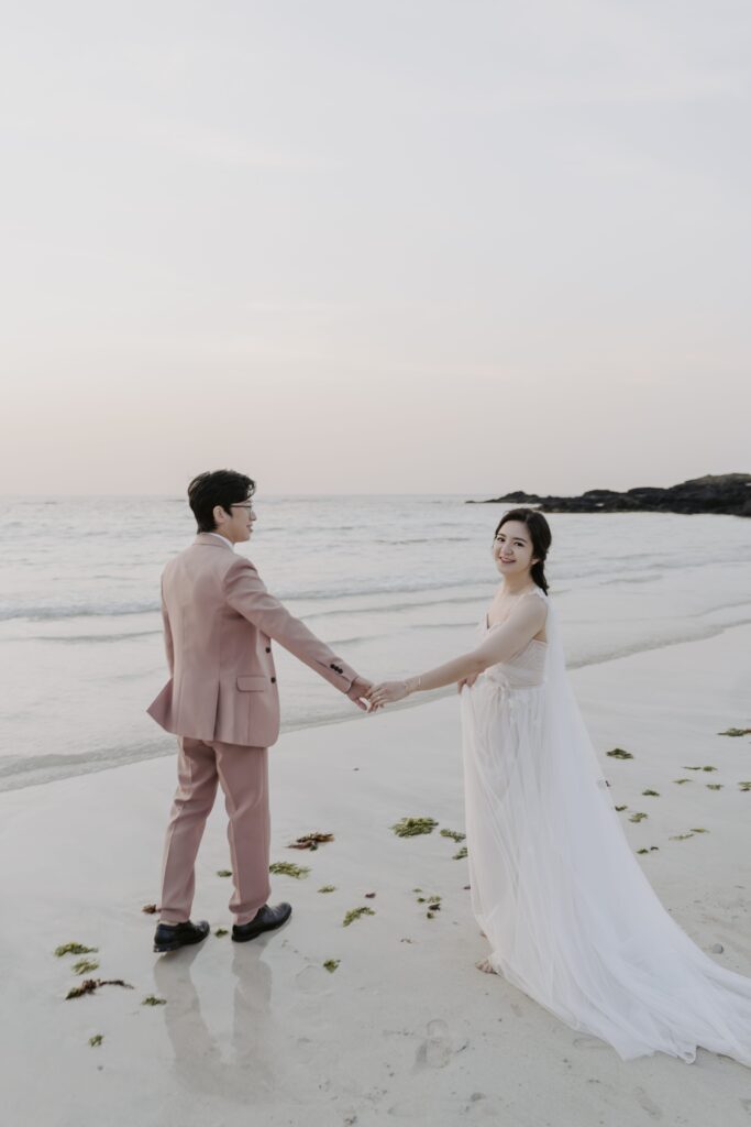 A bride and groom holding hands during their pre-wedding photoshoot on Jeju Island.