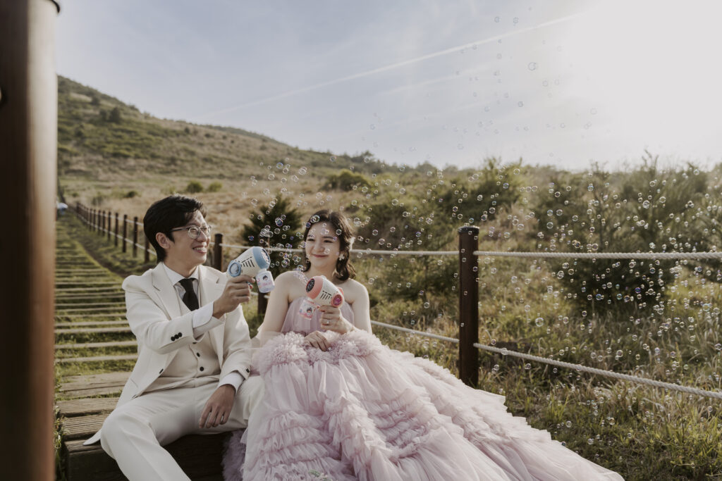 A couple during their pre-wedding photoshoot on a wooden bridge in Jeju Island.