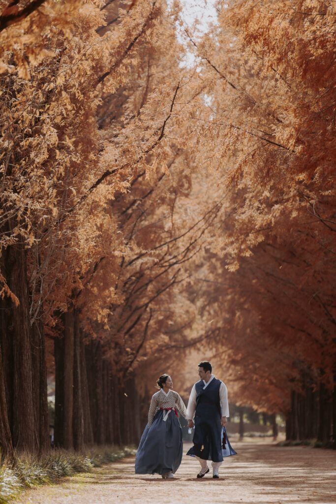 A couple walking down a path lined metasequoia trees