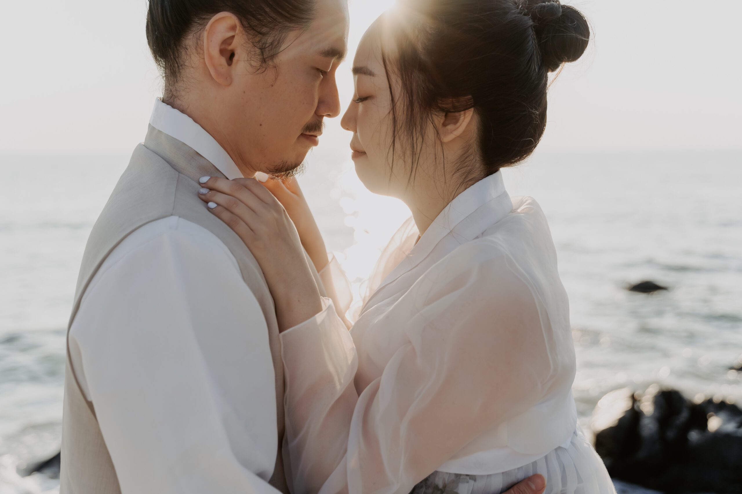 A pre-wedding couple embracing in front of the ocean in Jeju.